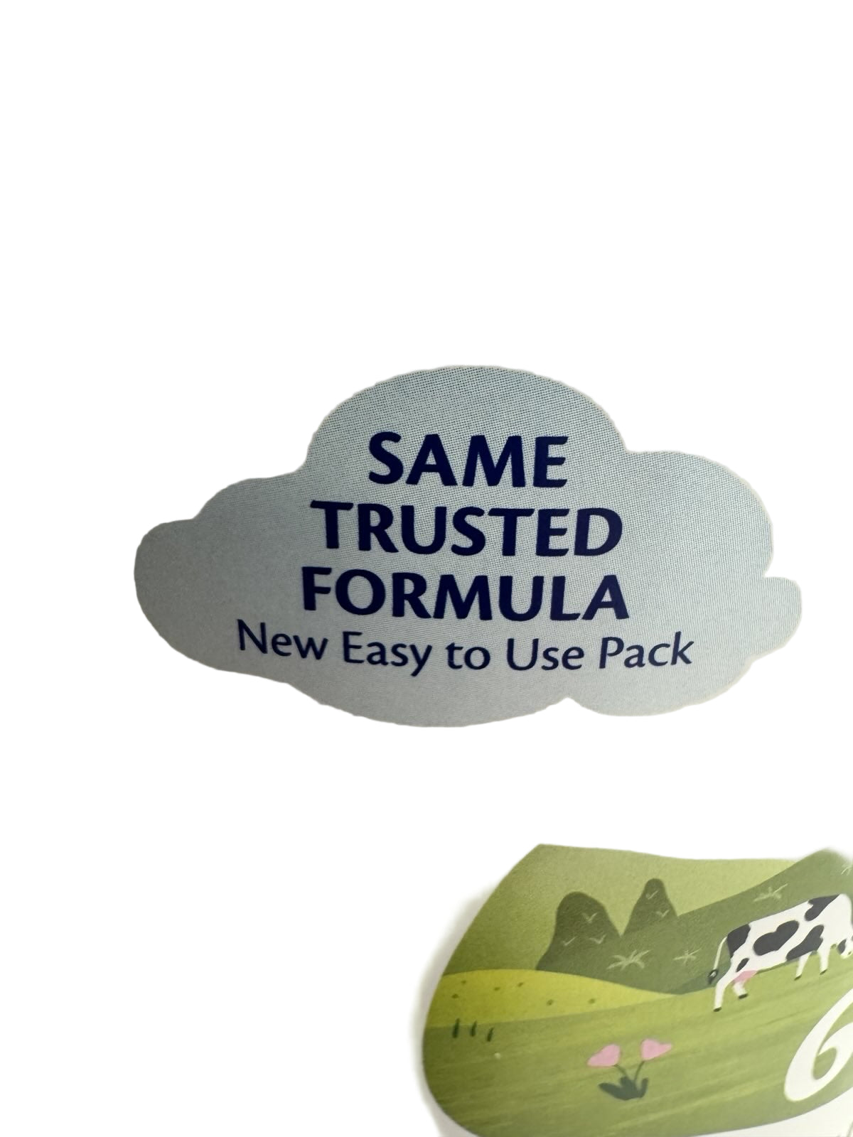 Product packaging with 'Same Trusted Formula' text and a cow illustration on a light background
