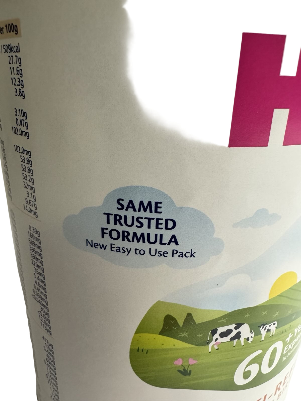 Container of baby formula with a scenic design and text about a trusted formula.