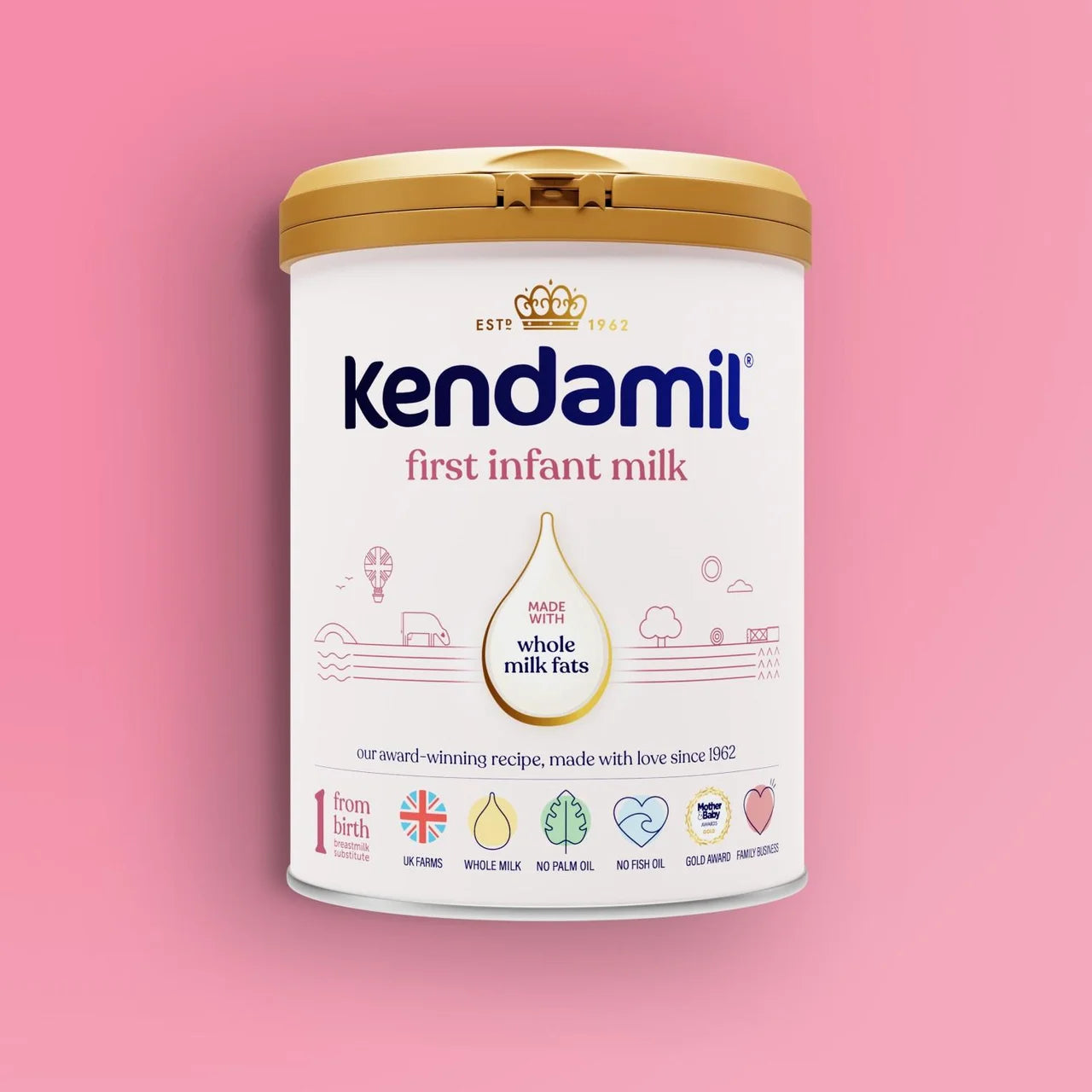 A canister of Kendamil First Infant Milk powder, featuring a white label with blue brand text and a gold lid, set against a solid pink background.