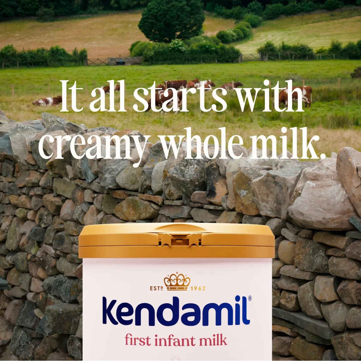 Kendamil first infant milk container with a scenic background of cows in a field.