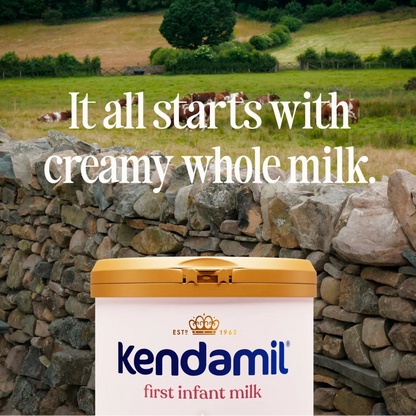 Kendamil first infant milk container with a scenic background of cows in a field.