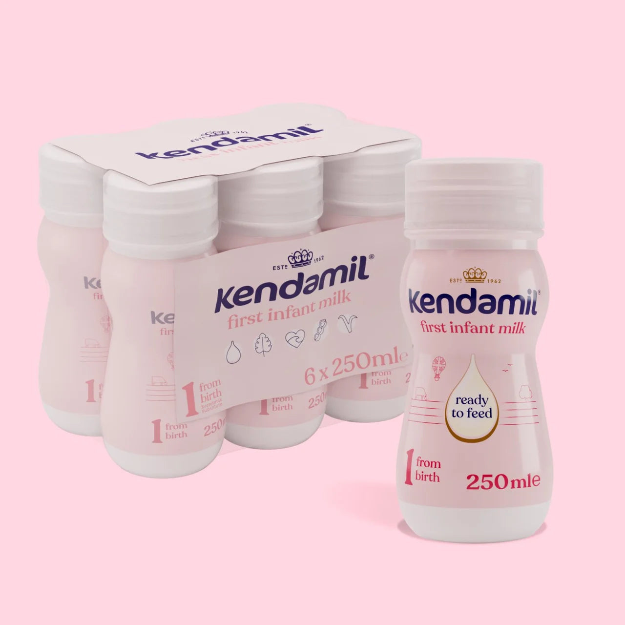 Kendamil first infant milk bottles and packaging on a pink background