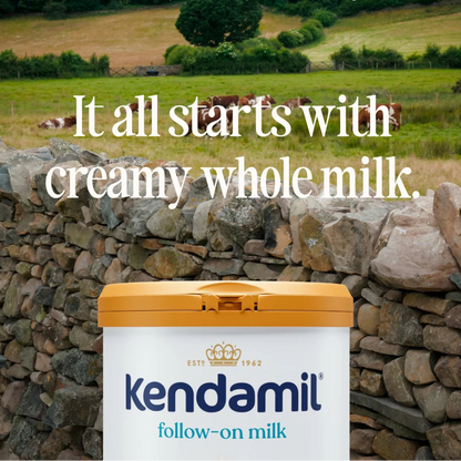 Kendamil follow-on milk container with a scenic background of cows in a field.