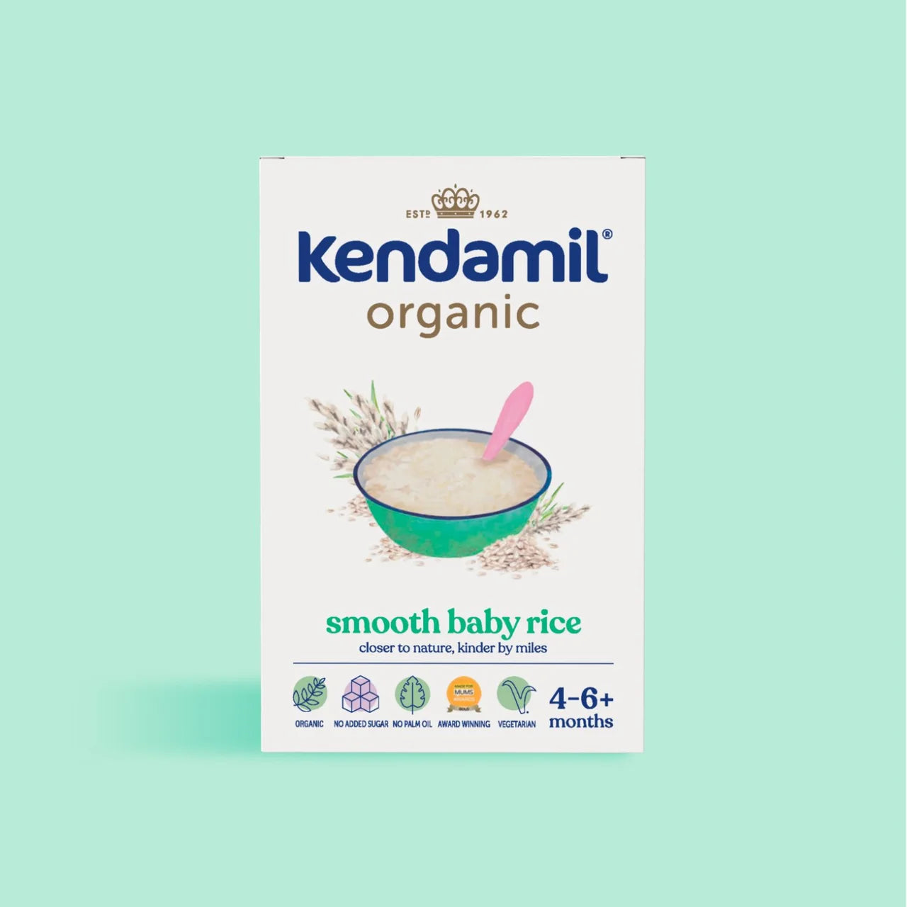 A box of Kendamil Organic Smooth Baby Rice on a solid mint green background. The packaging is white with blue and green text, featuring an illustration of a bowl of rice with a pink spoon.
