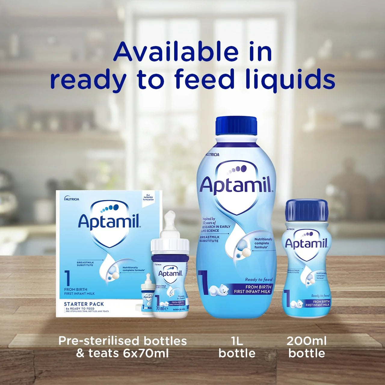 Aptamil ready-to-feed liquid bottles and teats shown on a wooden surface with a blurred kitchen background. Large blue text at the top reads 'Available in ready to feed liquids,' and text at the bottom lists starter pack, 1L bottle, and 200ml bottle sizes.