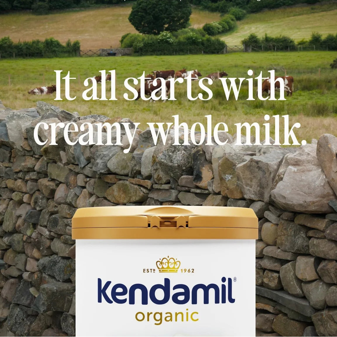 Kendamil organic milk container with a scenic background of cows in a field.