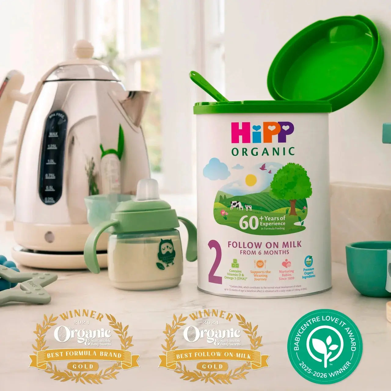 Hipp Organic baby formula can with a sippy cup on a kitchen counter, surrounded by baby products.