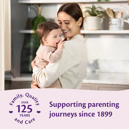 Woman holding a baby in a kitchen with text about supporting parenting journeys since 1899.