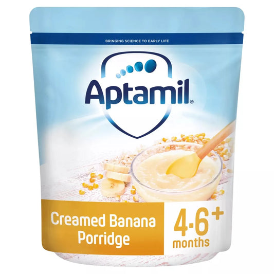 Aptamil Creamed Banana Porridge in a light blue and white stand-up pouch, featuring a bowl of banana cream and banana slices on the front, with '4.6+ months' printed on a yellow-orange banner at the bottom.